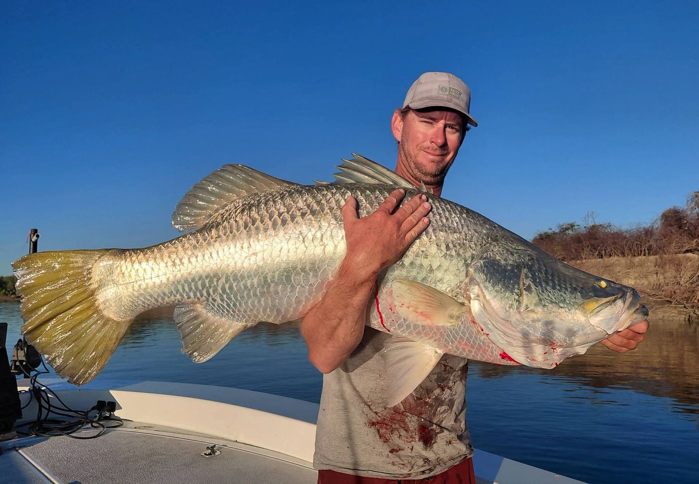 Angler hugging a very large barramundi at sunset